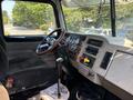 Interior of a 2008 Peterbilt 340 featuring a wooden steering wheel shift gear and various control gauges on the dashboard