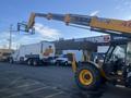 A yellow 2013 JCB 510-56 Loadall with an extended telehandler and fork attachment positioned to lift an object