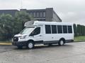 A 2021 Ford Transit-350 passenger van with a white and brown exterior parked in profile view