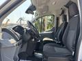 Interior of a 2019 Ford Transit 350 featuring two front seats with black fabric upholstery and a dashboard with controls and displays