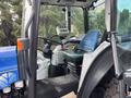 Interior view of a 2009 New Holland T4020 tractor featuring a blue seat control panel and steering wheel