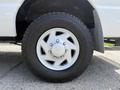 A close-up view of a silver wheel rim with five spokes and a rugged tire labeled Cooper Discoverer STT mounted on a 2008 Ford Econoline