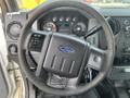 Steering wheel of a 2014 Ford F-250 SD with controls and Ford logo visible on the center hub
