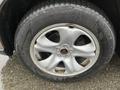 A close-up of a silver wheel with five spokes and a black tire featuring the Michelin logo and visible wear marks
