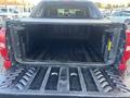 The image shows the open truck bed of a 2011 Chevrolet Avalanche with a textured black liner and interior dividers designed for storage and transportation purposes