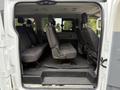 Interior view of a 2017 Ford Transit T150 XLT showcasing a row of dark fabric seats with adjustable headrests and a spacious cabin layout