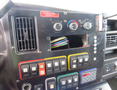 Control panel of a 2011 Chevrolet Express with multiple switches knobs and an empty slot for additional equipment wires are visible