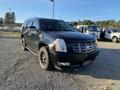 A black 2007 Cadillac Escalade with chrome accents and oversized tires parked on gravel
