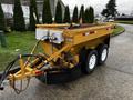 A yellow 2015 Camoplast SW 4S trailer with a flatbed design and dual wheels connected to hydraulic and electrical lines