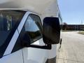 A side view of a 2020 Chevrolet Express showing the side mirror and part of the front door with a white and black color scheme