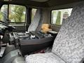 Interior view of a 2009 UD Trucks UD 3300 with two gray upholstered seats and a central control panel featuring various buttons and dials