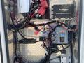 A 2011 Chevrolet Express has its interior electrical components exposed, including wiring, control units, and connectors arranged in a neat configuration