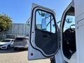 A 2006 Freightliner M2 106 truck with an open driver's door showcasing the interior and side mirror