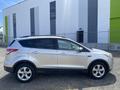 A silver 2015 Ford Escape is parked with its profile visible showcasing its sleek design and alloy wheels