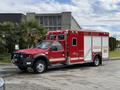 A red 2007 Ford F-550 fire rescue vehicle with emergency lights and equipment compartments on the sides