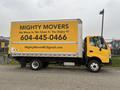 A yellow 2019 Hino 155 moving truck with a large side advertisement for Mighty Movers featuring contact information and a tagline