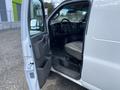 A 2023 GMC Savana van with the driver's side door open revealing the interior including the driver's seat and dashboard