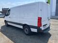 A 2022 Mercedes-Benz Sprinter van with a white exterior and black accents showing a sliding door and a rear license plate