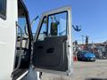 A 2011 International 4300 truck with an open door revealing the interior seating and control area