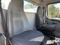 Two grey cloth seats inside the cabin of a 2005 Freightliner M2 106 with armrests and seatbelts visible