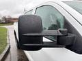 Close-up of the side mirror on a white 2015 GMC Sierra 1500 covered in raindrops