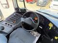 The interior of a 2009 International 3000 CE school bus featuring a driver’s seat a steering wheel and various dashboard controls and gauges