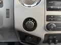 Dashboard controls of a 2015 Ford F-550 including a circular knob for selecting drive modes and various buttons for climate and audio settings
