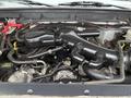 The image shows the engine compartment of a 2012 Ford F-450 SD with various components including hoses and an air intake system visible