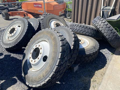 Set of 10 heavy duty tires stacked and leaning against each other