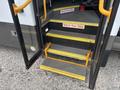 A 2020 Chevrolet Express with open doors revealing steps that have yellow markings and a safety notice to watch your step