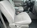 Interior of a 2004 Toyota Tacoma featuring light gray cloth seats and a central console with gear shift and controls