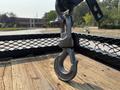 Close-up of a heavy-duty metal hook attached to a winch on a truck's bed designed for towing and heavy lifting