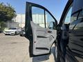 A 2016 Ford Transit 150 with an open driver's side door revealing the interior features and controls
