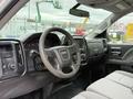 Interior view of a 2016 GMC Sierra 1500 showing the steering wheel dashboard and front seats in light gray upholstery