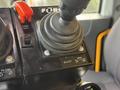 Close-up of a control panel featuring a joystick with a rubber grip and buttons labeled with functions including "Blast" "Wing Up" "Wing Down" and an emergency panic switch