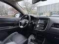 Interior of a 2016 Mitsubishi Outlander featuring a black dashboard leather seats and a touchscreen display on the center console