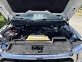 A 2021 Ford F-150 with its hood raised exposing the engine compartment including the engine the battery and various components