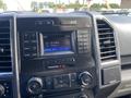Dashboard of a 2015 Ford F-150 showing radio controls and a digital display with time and temperature