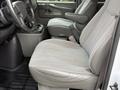 Interior view of a 2004 Chevrolet Express showing the driver's seat and passenger seat both in gray fabric with a console and controls visible between them