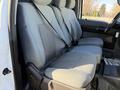 A set of three cloth seats in a 2010 Ford F-450 interior with seatbelts attached