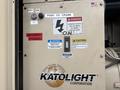 A control panel for a Katolight SED60FPJ4 generator featuring power switch, warning labels, and buttons for operation