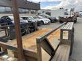 A rusty 2013 JLG Industries 1014 lift with a metal platform and large wheels positioned in a parking lot
