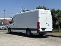 White 2019 Mercedes-Benz Sprinter van parked with a streamlined design and side windows showing a spacious cargo area