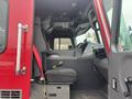 Interior of a 2006 E-One Typhoon fire truck showing driver's seat and dashboard controls with a red seatbelt visible