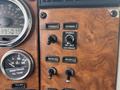 The interior dashboard of a 2008 Peterbilt 340 showing gauges and various control switches for mirror, exhaust brake, engine fan, and beacon light