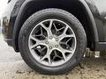 Close-up of a Jeep Grand Cherokee wheel showcasing a multi-spoke alloy rim with Pirelli tires and visible tread patterns
