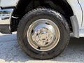 Close-up of a shiny chrome wheel and tire on a 2013 Ford Econoline with visible tread pattern and branding on the tire