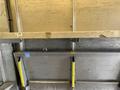 A 2012 Ford Econoline van interior showing metal walls with a wooden plank and yellow supports in the foreground