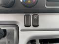 Dashboard controls of a 2015 Mitsubishi Fuso FE160 featuring two buttons one with an auto symbol and the other without labeling