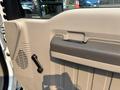 The interior door panel of a 2009 Ford F-450 Super Duty featuring a speaker grille a door handle and a window crank